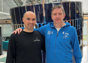 Space4Good founder in black sweatshirt with SBIC COO in blue hoodie space stood together by the satellite at SBIC Noordwijk