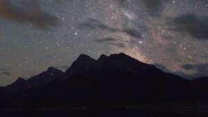 shadowy mountainscape against a starry sky