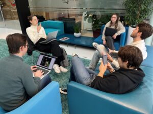 Student delegation sitting in a group at SBIC Noordwijk working on business challenges about the space industry