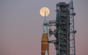 Artemis II rocket on its launchpad with the full Moon in the background