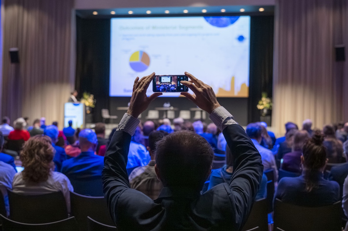 delegate holding camera in a conference audience